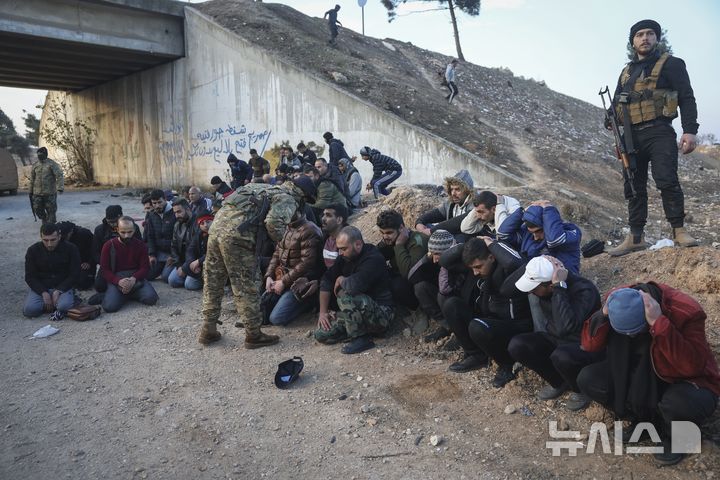 [AP/뉴시스] 수도 다마스쿠스로 오는 길목에서 반정부군에 사로잡힌 정부군 및 협력자들이 홈스 인근에서 무릎꾾고 앉아 있다 
