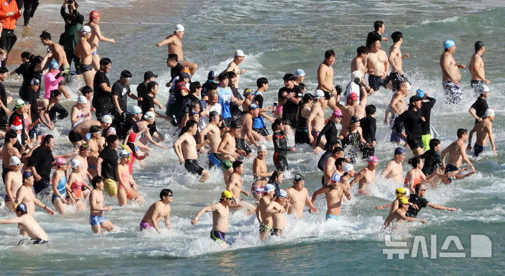 [부산=뉴시스] 하경민 기자 = '제37회 해운대 북극곰 축제'가 열린 8일 부산 해운대구 해운대해수욕장에서 시민과 관광객 등 인간 북극곰들이 일제히 차가운 겨울바다에 뛰어들고 있다. 2024.12.08. yulnetphoto@newsis.com