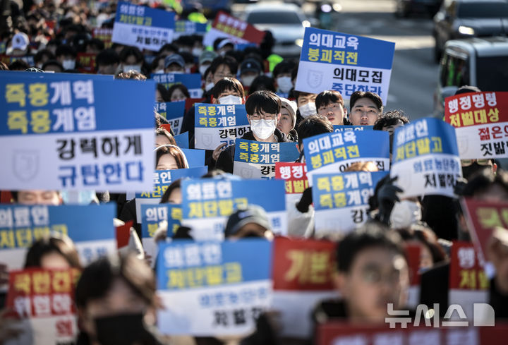 [서울=뉴시스] 정병혁 기자 = 지난 8일 서울 종로구 대학로에서 열린 서울대병원 전공의협의회 비상대책위원회 ‘젊은 의사 의료계엄 규탄 집회’에서 사직 전공의를 비롯한 젊은 의사들이 피켓을 들고 있는 모습. 2024.12.08. jhope@newsis.com