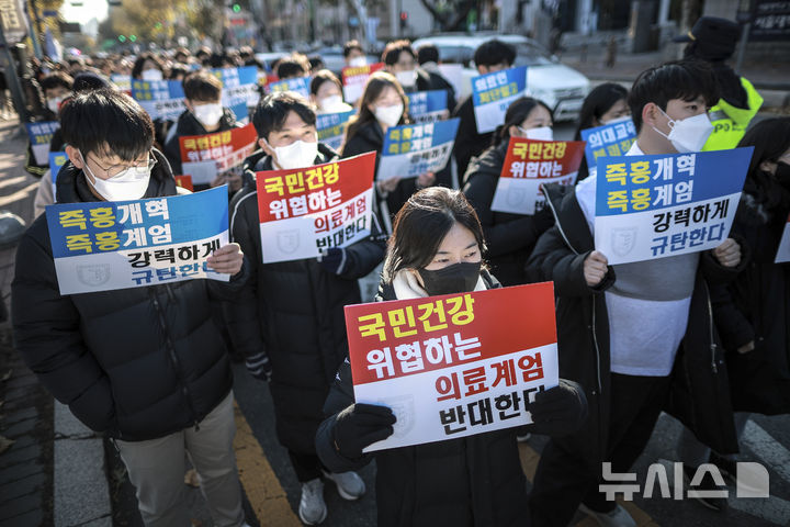 [서울=뉴시스] 정병혁 기자 = 8일 서울 종로구 대학로에서 열린 서울대병원 전공의협의회 비상대책위원회 ‘젊은 의사 의료계엄 규탄 집회’에서 사직 전공의를 비롯한 젊은 의사들이 피켓을 들고 있다. 2024.12.08. jhope@newsis.com