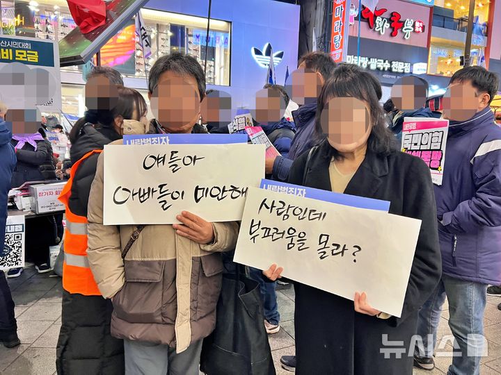 [부산=뉴시스] 원동화 기자 = 9일 부산 부산진구 서면 젊음의 거리에서 진행된 윤석열 퇴진(윤퇴진) 부산운동본부가 주최한 '내란공범 국힘당도 한 세트로 뿌리뽑자! 내란범 윤석열 탄핵 체포 부산시민대회'. 60대와 50대로 보이는 한 남성과 여성은 각각 '얘들아 아빠들이 미안해' '사람인데 부끄러움을 몰라?'라는 팻말을 들고 젊은 세대들을 찾아다니면서 안아주기도 했다. 2024.12.09. dhwon@newsis.com