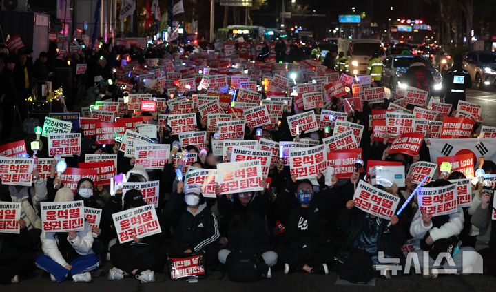 [인천=뉴시스] 전진환 기자 = 9일 오후 인천 미추홀구 농수산물시장사거리에서 열린 '내란주범 윤석열 즉각 체포! 윤석열 탄핵! 국민의힘 해체!  사회대개혁 쟁취! 인천시민촛불' 집회에서 참가자들이 팻말과 응원봉을 들고 구호를 외치고 있다. 2024.12.09. amin2@newsis.com