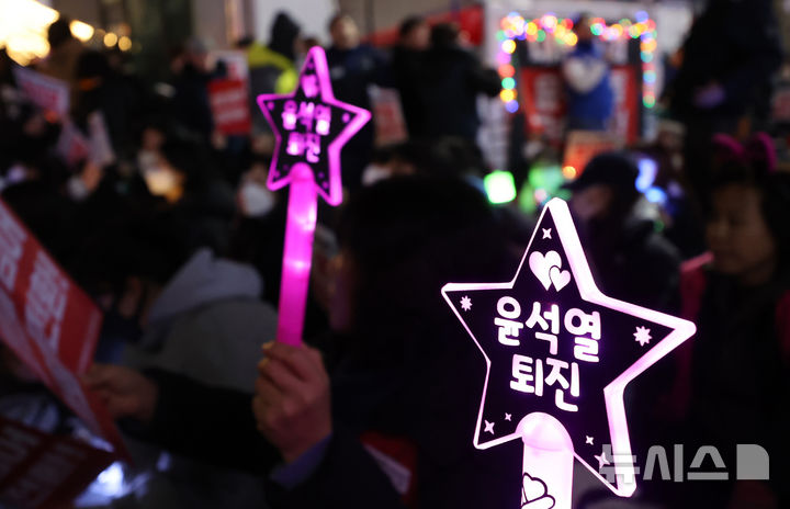 [인천=뉴시스] 전진환 기자 = 지난해 12월 9일 오후 인천 미추홀구 농수산물시장사거리에서 열린 '내란주범 윤석열 즉각 체포! 윤석열 탄핵! 국민의힘 해체! 사회대개혁 쟁취! 인천시민촛불' 집회에서 시민들이 팻말과 응원봉을 들고 있다. 2024.12.09. amin2@newsis.com