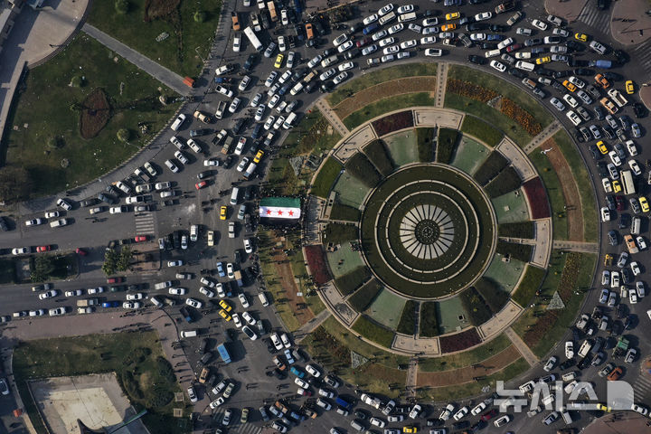 [다마스쿠스=AP/뉴시스] 지난 9일(현지시각) 시리아 다마스쿠스 우마이야 광장에서 시민들이 대형 혁명기를 들고 바샤르 알아사드 정권의 붕괴를 축하하고 있다. 2024.12.17.