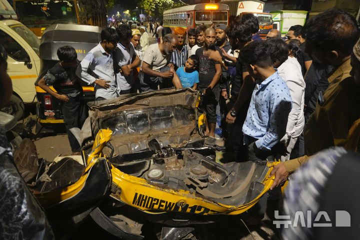 [뭄바이=AP/뉴시스] 2024년 12월 사진으로 인도 뭄바이 교통사고 현장에서 사람들이 전동 인력거 오토릭샤 잔해 주변에 모여 있다. 2024.12.10.