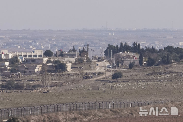 [AP/뉴시스] 이스라엘 점령의 골란 고원에서 바라다본 모습으로 10일 이스라엘 탱크들이 완충지대 내 퀴네이트라 통과지 부근에서 움직이고 있다. 이스라엘군은 이미 철망 너머 시리아 지대 쪽으로 진입했다. 