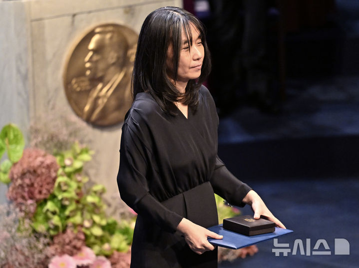 [스톡홀름=AP/뉴시스]한강이 10일(현지시각) 스웨덴 수도 스톡홀름 소재 콘서트홀에서 열린 노벨상 시상식에서 칼 구스타프 16세 스웨덴 국왕으로부터 문학상 메달과 증서를 받고 있다. 2024.12.11.