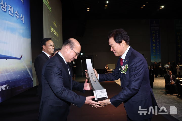 [창원=뉴시스]박완수(오른쪽) 경남도지사가 11일 창원 그랜드머큐어앰배서더 호텔에서 열린 제30회 경남무역인상 시상식 및 제61회 무역의 날 정부포상 전수식에서 DN솔루션즈 관계자에게 팔억불 수출의탑을 전수하고 있다.(사진=경남도 제공)2024.12.11. photo@newsis.com