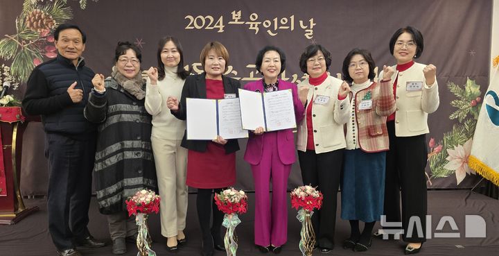 [수원=뉴시스]송은경 회장(죄측)과 이순배 학회장이 협약서에 서명한 뒤 임원들과 기념사진을 찍고 있다.(사진=수원시어린이집협의회 제공) 2024.12.12. photo@newsis.com