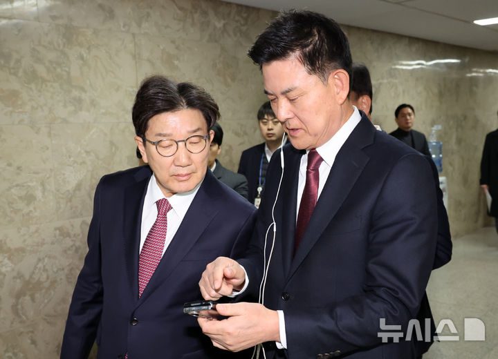 [서울=뉴시스] 조성우 기자 = 김태호(오른쪽), 권성동 국민의힘 원내대표가 후보가 12일 오후 서울 여의도 국회에서 열린 2024 원내대표 선출 선거 의원총회에서 휴대전화로 윤석열 대통령 대국민 담화를 시청하고 있다. 2024.12.12. xconfind@newsis.com