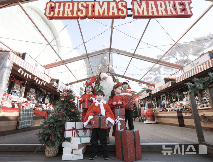 [서울=뉴시스] 정병혁 기자 = 12일 서울 송파구 롯데월드몰 잔디관장에서 열린 롯데 크리스마스 마켓에서 어린이들이 핀란드에서 온 공식 산타와 기념촬영을 하고 있다. 2024.12.12. jhope@newsis.com