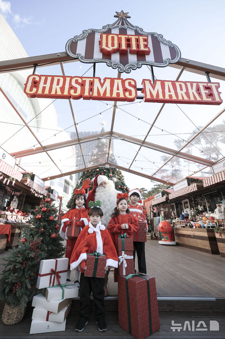 [서울=뉴시스] 정병혁 기자 = 12일 서울 송파구 롯데월데몰 잔디관장에서 열린 롯데 크리스마스 마켓에서 어린이들이 핀란드에서 온 공식 산타와 기념촬영을 하고 있다. 2024.12.12. jhope@newsis.com