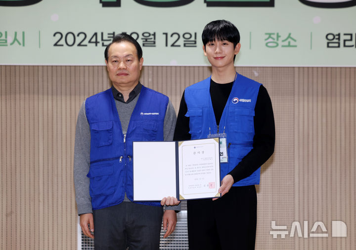 [서울=뉴시스] 김명년 기자 = 배우 정해인이 12일 오전 서울 마포구 염리종합사회복지관에서 열린 '행복공감봉사단 취약계층 위한 따뜻한 한 끼 나눔 봉사활동' 행사에서 이용욱 복권위원회 사무처장에게 감사장을 수여받은 후 기념촬영하고 있다. 2024.12.12. kmn@newsis.com