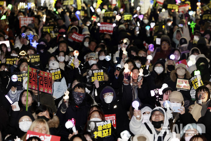 [서울=뉴시스] 최동준 기자 = 지난 12일 서울 영등포구 국회 앞에서 촛불집회 참가자들이 윤석열 대통령 탄핵을 촉구하고 있다. 2024.12.13. photocdj@newsis.com