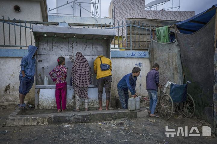 [데이르 알발라=AP/뉴시스] 12월12일 가자지구 데이르 알발라 난민 캠프에서 팔레스타인 어린이들이 물을 받고 있다. 하지만 이스라엘군은 가자 북부 지역에 대한 유엔의 식량과 물, 의약품 반입까지 철저히 막고 있다. 2024.12.18.