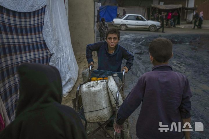 [데이르 알발라=AP/뉴시스]세계 인권 증진·보호를 위해 활동하는 비정부기구(NGO) 휴먼라이츠워치(HRW)는 이스라엘이 팔레스타인 가자지구에 물을 고의로 끊어 대량학살을 벌였다고 주장했다. 사진은 지난 12일(현지시각) 팔레스타인 가자지구 데이르 알발라 난민 캠프에서 한 팔레스타인 소년이 물을 길어 수레로 나르는 모습. 2024.12.20.