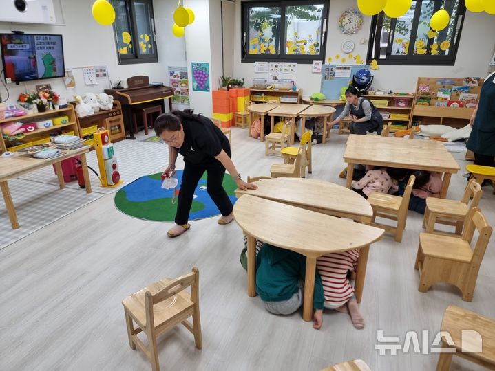 [용인=뉴시스] 어린이들이 책상 밑에 대피하며 재난사고에 대비한 안전체험교육을 받고 있다. (사진=용인시 제공) 2024.12.13. photo@newsis.com