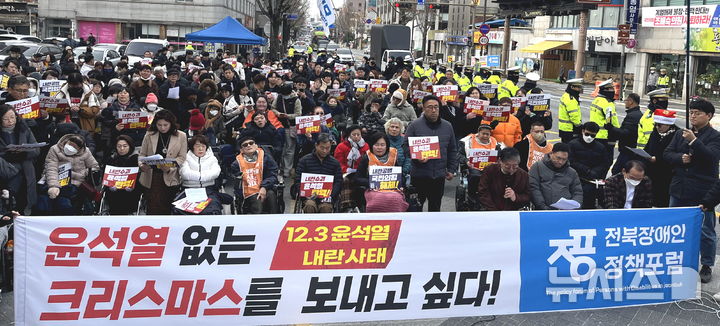 [전주=뉴시스] 김얼 기자 = 전북장애인정책포럼 관계자들이 13일 전북 전주시 국민의힘 전북특별자치도당 앞에서 열린 '윤석열 없는 크리스마스 선포식'에 참석해 손피켓을 들고 윤석열 대통령 퇴진을 촉구하고 있다. 2024.12.13. pmkeul@newsis.com