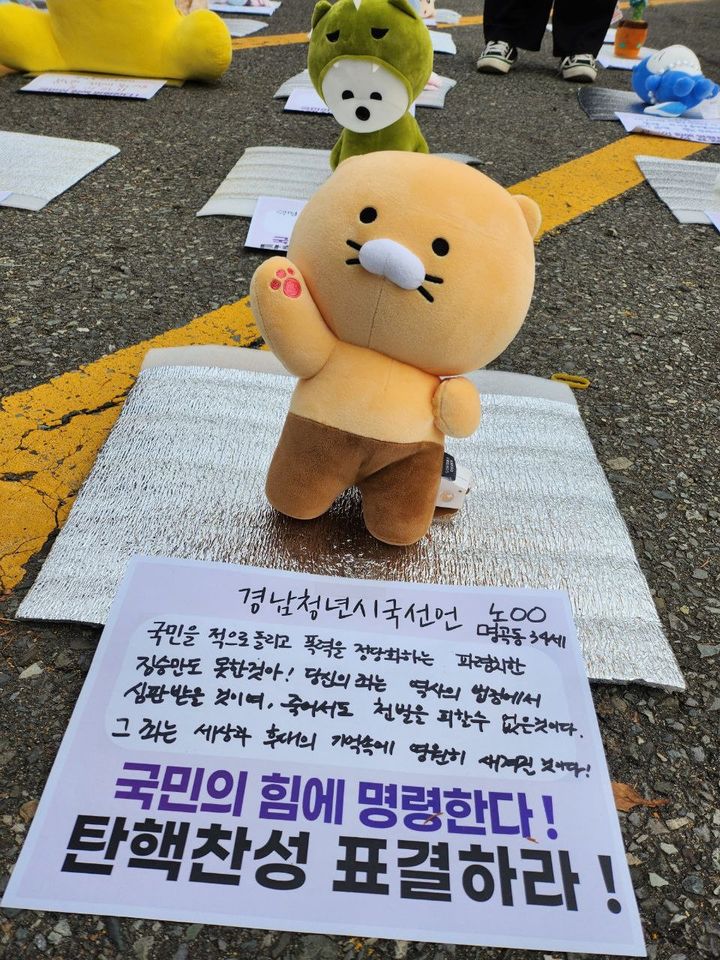 [창원=뉴시스] 강경국 기자 = 13일 경남도청 앞에서 경남청년유니온 시국선언이 진행된 가운데 회원들을 대신해 인형과 분노의 한마디가 담긴 메모지가 놓여 있다. (사진=창원시청 제공). 2024.12.13. photo@newsis.com *재판매 및 DB 금지