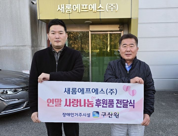 [천안=뉴시스] 새롬에프에스 노영래(오른쪽) 전무가 구산원에 생필품을 전달하고 기념 사진을 찍고 있다. (사진=구산원 제공) 2024.12.13. photo@newsis.com *재판매 및 DB 금지