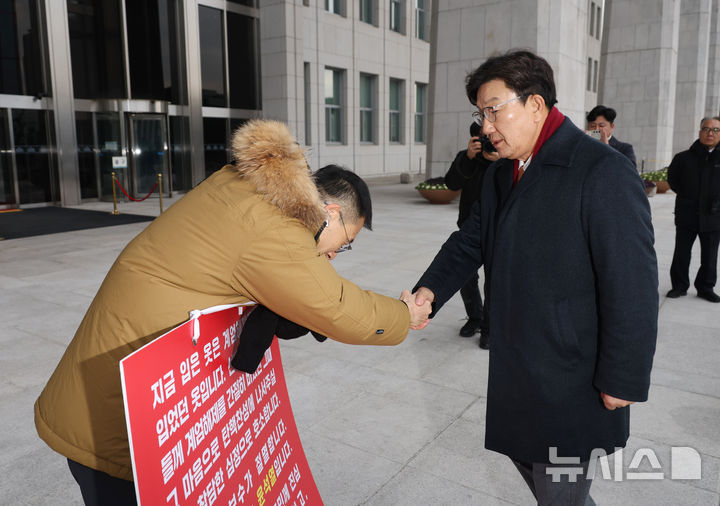 [서울=뉴시스] 고승민 기자 = 권성동 국민의힘 원내대표가 13일 서울 여의도 국회에서 윤석열 대통령의 탄핵을 촉구하며 1인시위 중인 김상욱 의원과 악수하고 있다. 2024.12.13. kkssmm99@newsis.com