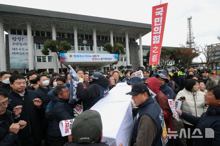 [제주=뉴시스] 우장호 기자 = 전국농민회총연맹 제주도연맹과 도내 진보정당 관계자들이 13일 오후 제주도의회 앞에서 열린 '내란수괴 윤석열 체포·구속! 내란공범 국민의힘 해체! 제주농민대회' 집회에서 국민의힘 장례식을 치르고 있다. 2024.12.13. woo1223@newsis.com