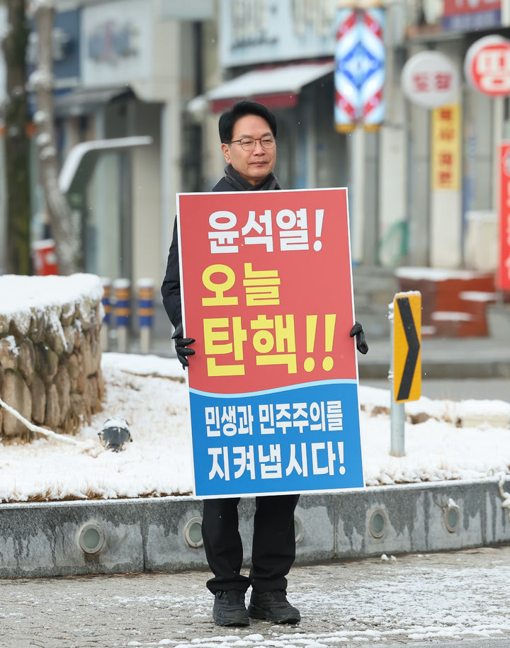 [고창=뉴시스] 14일 오전 고창군청 앞 회전교차로, 눈이 내리고 그치기를 반복하는 추운 날씨, 심덕섭 군수가 윤석열 대통령의 탄핵을 외치며 1인 시위를 하고 있다. *재판매 및 DB 금지