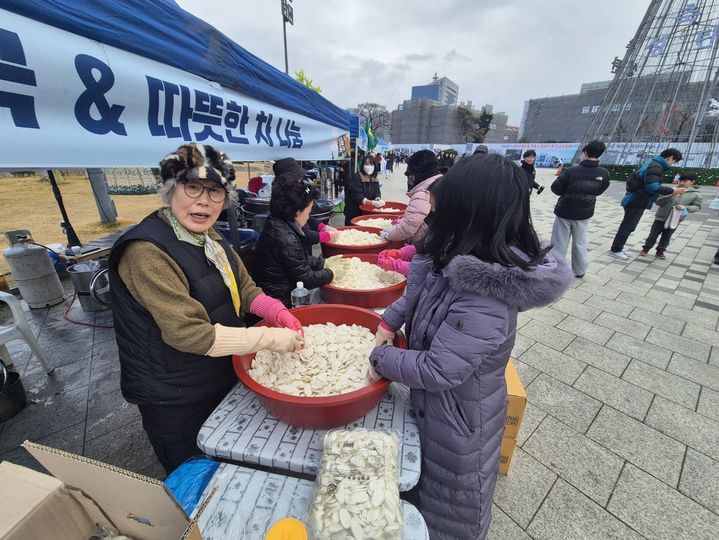 [광주=뉴시스] 변재훈 기자 = 윤석열 대통령 탄핵소추안 2차 표결이 열리는 14일 오후 광주 동구 금남로에서 집회에 모인 시민을 위한 떡국 나눔 부스가 마련돼있다. 2024.12.24. wisdom21@newsis.com *재판매 및 DB 금지