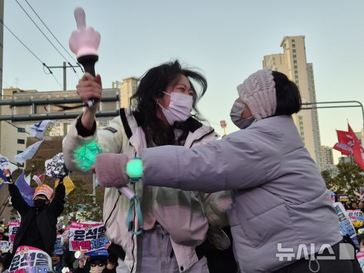 [부산=뉴시스] 권태완 기자 = 윤석열 대통령의 탄핵 소추안 재표결이 가결된 14일 오후 부산 부산진구 전포대로에서 시민들이 환호하고 있다. 2024.12.14. kwon97@newsis.com