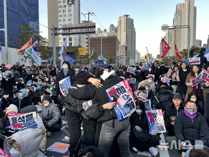 [부산=뉴시스] 권태완 기자 = 윤석열 대통령의 탄핵 소추안 재표결이 가결된 14일 오후 부산 부산진구 전포대로에서 시민들이 환호하고 있다. 2024.12.14. kwon97@newsis.com