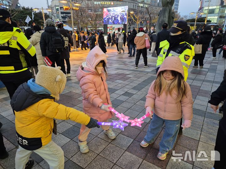 [울산=뉴시스] 구미현 기자 = 윤석열 대통령 탄핵소추안 재표결이 가결된 14일 울산 남구 롯데백화점 울산점 광장에서 어린이들이 탄핵이 적힌 응원봉을 들어보이고 있다. 2024.12.14. gorgeouskoo@newsis.com