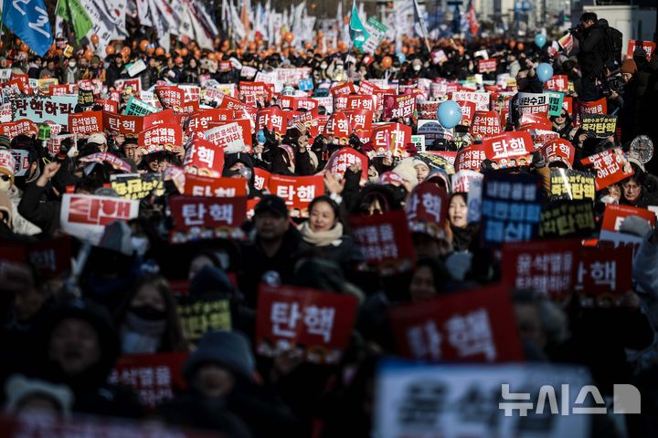 [서울=뉴시스] 정병혁 기자 = 지난 14일 서울 영등포구 국회 앞에서 열린 '내란수괴 윤석열 즉각탄핵' 범국민 촛불대행진에 참가한 시민들이 피켓을 들고 있다. 2024.12.14. jhope@newsis.com