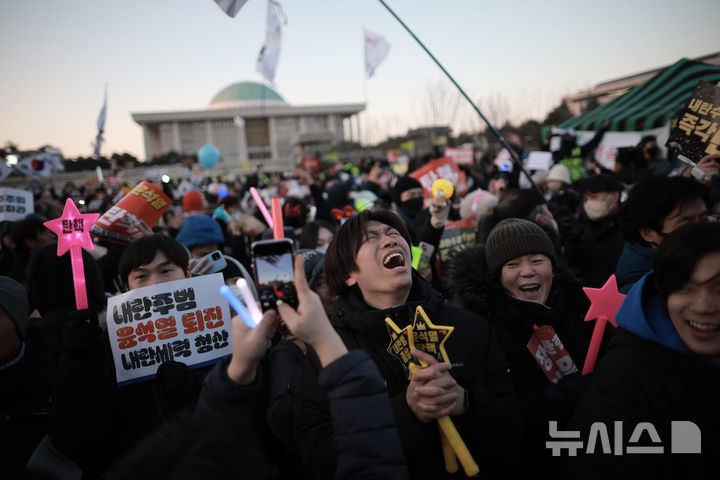 [서울=뉴시스] 정병혁 기자 = 윤석열 대통령 탄핵소추안이 가결된 14일 서울 영등포구 국회 앞에서 열린 '내란수괴 윤석열 즉각탄핵' 범국민 촛불대행진에서 시민들이 환호하고 있다. 2024.12.14. jhope@newsis.com