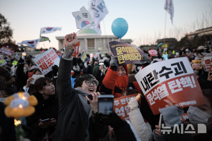 [서울=뉴시스] 정병혁 기자 = 윤석열 대통령 탄핵소추안이 가결된 14일 서울 영등포구 국회 앞에서 열린 '내란수괴 윤석열 즉각탄핵' 범국민 촛불대행진에서 시민들이 환호하고 있다. 2024.12.14. jhope@newsis.com