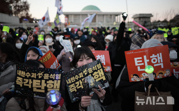 [서울=뉴시스] 정병혁 기자 = 윤석열 대통령 탄핵소추안이 가결된 14일 서울 영등포구 국회 앞에서 열린 '내란수괴 윤석열 즉각탄핵' 범국민 촛불대행진에서 시민들이 환호하고 있다. 2024.12.14. jhope@newsis.com