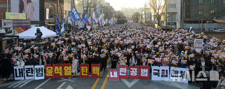 [전주=뉴시스] 김얼 기자 = 윤석열 대통령 탄핵소추안 재표결이 가결된 14일 전북 전주시 충경로에 모인 시민들이 환호성을 지르고 있다. 2024.12.14. pmkeul@newsis.com