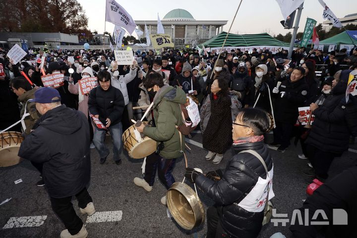 [서울=뉴시스] 최동준 기자 = 윤석열 대통령 탄핵안이 가결된 14일 서울 영등포구 국회 앞에서 열린 촛불집회에 참가한 시민들이 풍물놀이를 하고 있다. 2024.12.14. photocdj@newsis.com