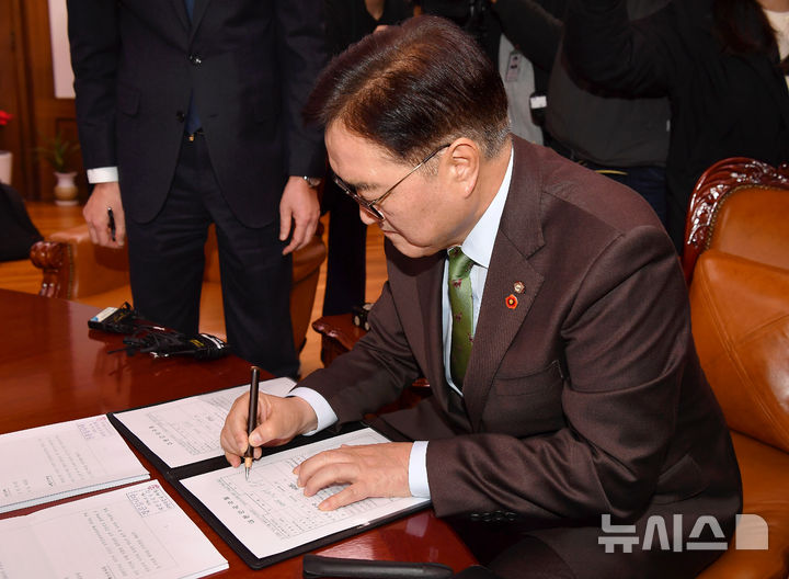 [서울=뉴시스] 권창회 기자 = 윤석열 대통령 탄핵안이 가결된 14일 오후 서울 여의도 국회 의장실에서 우원식 국회의장이 탄핵소추의결서에 서명하고 있다.(공동취재) 2024.12.14. photo@newsis.com