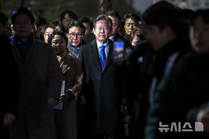 [서울=뉴시스] 정병혁 기자 = 윤석열 대통령 탄핵소추안 재표결이 가결된 14일 서울 영등포구 국회 앞에서 이재명 더불어민주당 대표가 '내란수괴 윤석열 즉각탄핵' 범국민 촛불대행진에 참석한 시민들에게 인사를 하기 위해 이동하고 있다. 2024.12.14. jhope@newsis.com