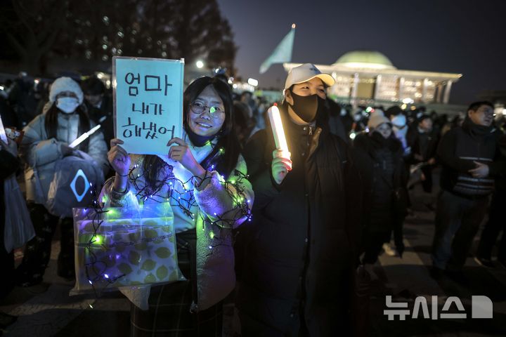 [서울=뉴시스] 정병혁 기자 = 윤석열 대통령 탄핵소추안 재표결이 가결된 14일 서울 영등포구 국회 앞에서 열린 '내란수괴 윤석열 즉각탄핵' 범국민 촛불대행진에서 시민들이 기뻐하고 있다. 2024.12.14. jhope@newsis.com