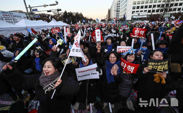 [서울=뉴시스] 김근수 기자 = 윤석열 대통령에 대한 탄핵 소추안 재표결이 통과된 14일 서울 여의도 국회의사당 앞에서 시민들이 윤석열 대통령 탄핵소추안 국회 통과 촉구 집회에서 기뻐하고 있다. 2024.12.14. ks@newsis.com