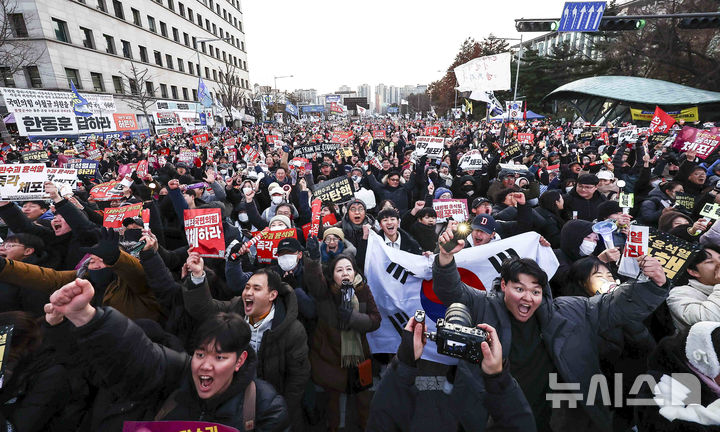 [서울=뉴시스] 김근수 기자 = 윤석열 대통령에 대한 탄핵 소추안 재표결이 통과된 14일 서울 여의도 국회의사당 앞에서 시민들이 윤석열 대통령 탄핵소추안 국회 통과 촉구 집회에서 기뻐하고 있다. 2024.12.14. ks@newsis.com