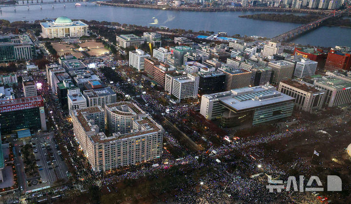 [서울=뉴시스] 김선웅 기자 = 윤석열 대통령에 대한 국회 탄핵소추안이 가결된 14일 서울 여의도 국회의사당 앞에서 열린 촛불집회에서 시민들이 형형색색의 야광봉을 들고 환호하고 있다. 2024.12.14. mangusta@newsis.com