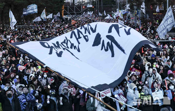 [서울=뉴시스] 김근수 기자 = 윤석열 대통령에 대한 탄핵 소추안 재표결이 통과된 14일 서울 여의도 국회의사당 앞에서 시민들이 윤석열 대통령 탄핵소추안 국회 통과 촉구 집회에서 기뻐하고 있다. 2024.12.14. ks@newsis.com