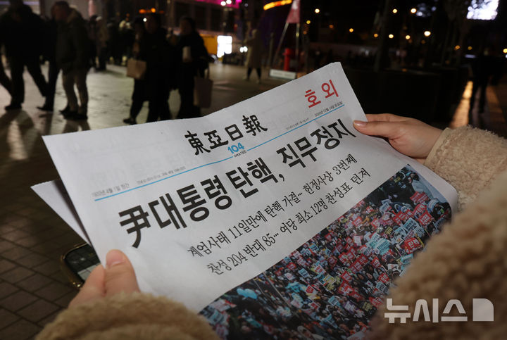 [서울=뉴시스] 홍효식 기자 = 사진은 2014년 12월14일 오후 서울 종로구 광화문역 일대에 한 시민이 윤석열 전 대통령 탄핵 가결 관련 호외를 읽고 있는 모습. 2024.12.14. yesphoto@newsis.com