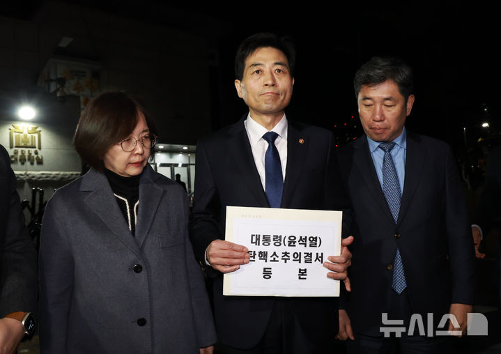 [서울=뉴시스] 조수정 기자 = 윤석열 대통령의 국회 탄핵소추안이 가결된 14일 김민기(가운데) 국회 사무총장이 탄핵소추의결서를 송달하기 위해 서울 용산 대통령실 청사 입구로 들어서며 발언하고 있다. 오른쪽은 조오섭 국회의장 비서실장. 탄핵소추의결서가 대통령실에 송달되는 즉시 윤 대통령의 직무가 정지된다. (대통령실통신사진기자단) 2024.12.14. chocrystal@newsis.com