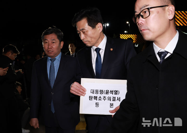 [서울=뉴시스] 조수정 기자 = 윤석열 대통령의 국회 탄핵소추안이 가결된 14일 김민기 국회 사무총장이 탄핵소추의결서를 송달하기 위해 서울 용산 대통령실 청사 입구에 도착해 내부로 이동하고 있다. 왼쪽은 조오섭 국회의장 비서실장. 탄핵소추의결서가 대통령실에 송달되는 즉시 윤 대통령의 직무가 정지된다. (대통령실통신사진기자단) 2024.12.14. chocrystal@newsis.com