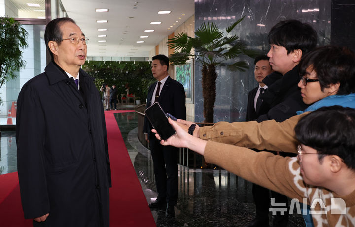 [서울=뉴시스] 김명원 기자 = 한덕수 대통령 권한대행 겸 국무총리가 15일 오전 서울 종로구 정부서울청사를 나서며 기자들의 질문에 답하고 있다. 2024.12.15. kmx1105@newsis.com