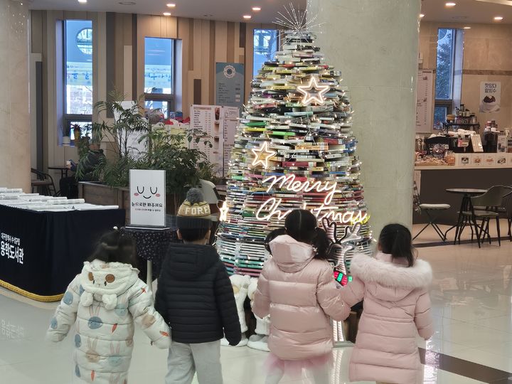 [대구=뉴시스] 수성구립 용학도서관은 연말을 맞아 책으로 만든 1000권의 책으로 쌓아 올린 '북트리'를 조성했다. (사진=수성구립 용학도서관 제공) 2024.12.16. photo@newsis.com *재판매 및 DB 금지