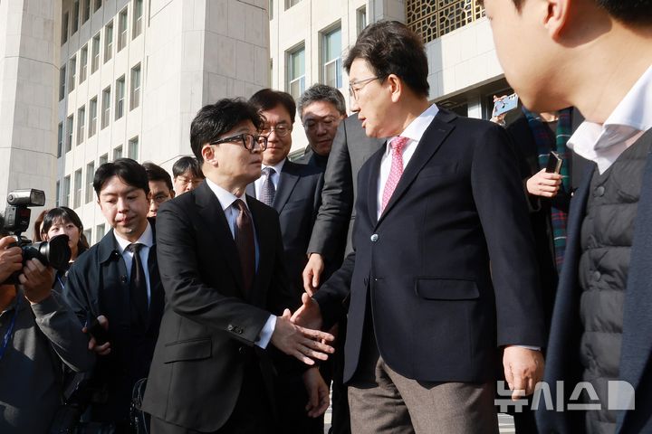 [서울=뉴시스] 국회사진기자단 = 한동훈 국민의힘 대표가 16일 오전 서울 여의도 국회에서 당대표 사퇴 기자회견을 마치고 차량에 탑승하며 권성동 원내대표와 악수를 하고 있다. 2024.12.16. photo@newsis.com